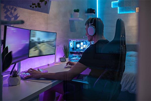 Pessoa sentada na sua cadeira gamer em seu quarto com iluminação personalizada para gamers